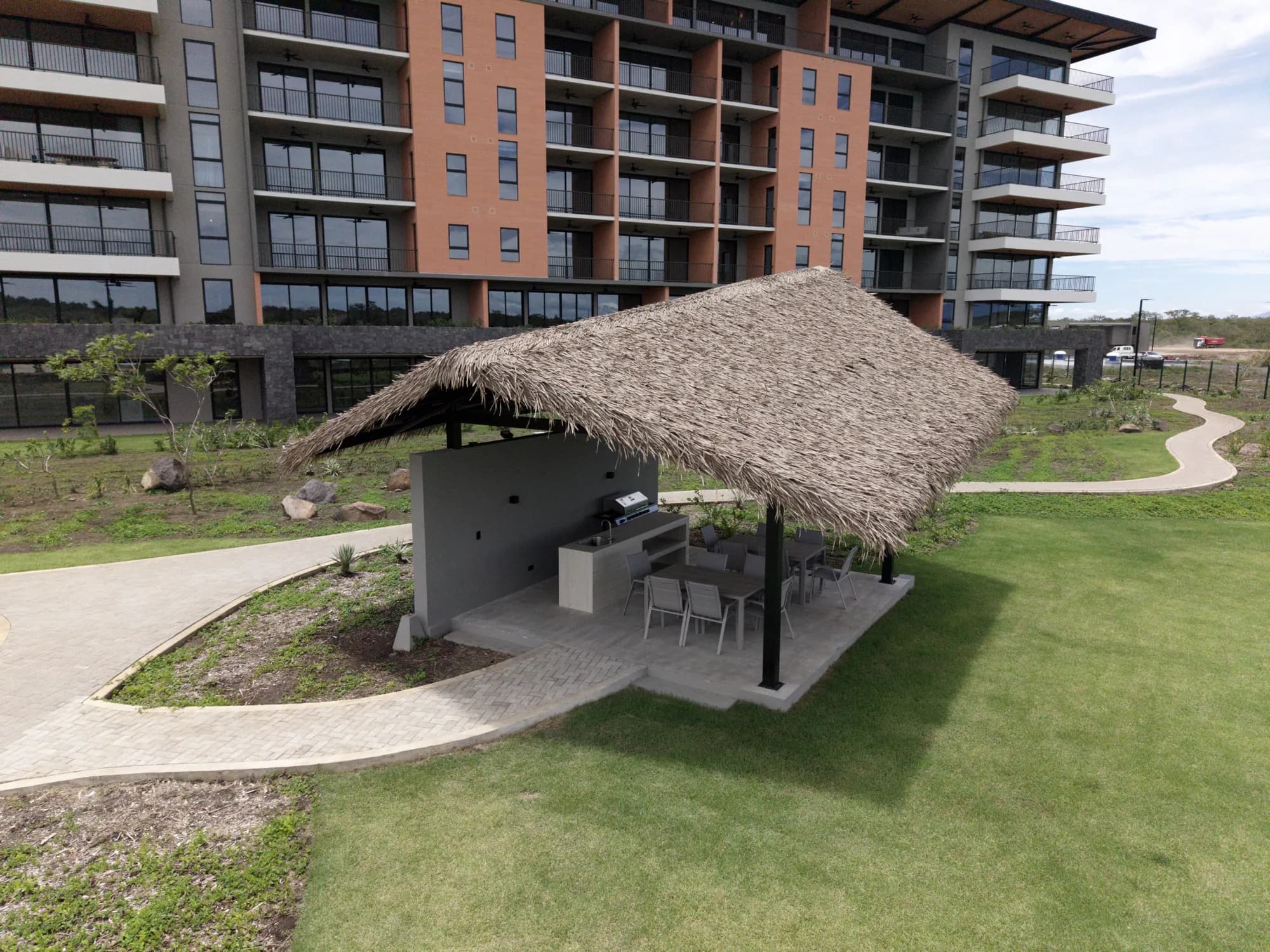 Synthetic thatch palapa at the foot of a residential tower